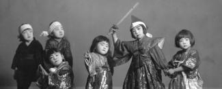 Black and white studio photo of six children posing in special Japanese costumes.