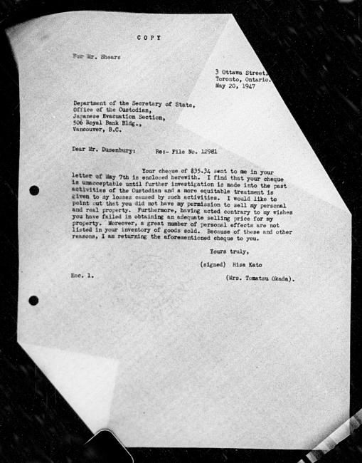 Un microfilm noir et blanc scanné d'une copie dactylographiée d'une lettre adressée au gouvernement de Hisa Kato et Tomatsu Okada concernant la dépossession de sa propriété. L'image a deux coins repliés qui obscurcit une grande partie de la lettre.